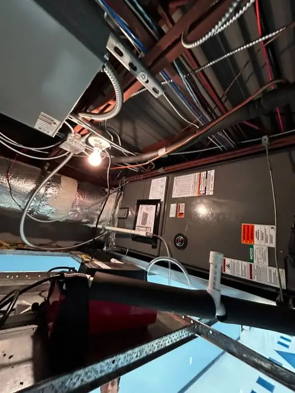 Insulated trunk duct under a work light in a dark Georgia attic